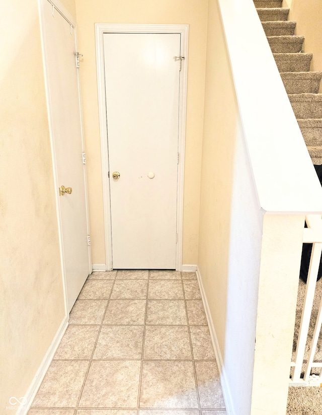 7906 States Bend Ln, Indianapolis, IN 46239 - corridor with stairs and light tile patterned floors