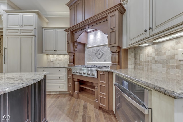 3795 Claybrook Ct, Bargersville, IN 46106 - kitchen with stainless steel gas stovetop, ornamental molding, light wood-style floors, decorative backsplash, and light stone counters