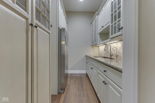 3795 Claybrook Ct, Bargersville, IN 46106 - kitchen with freestanding refrigerator, dark wood-type flooring, decorative backsplash, light stone counters, and glass insert cabinets