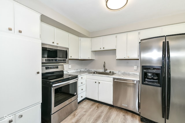 1543 W 79th St, Indianapolis, IN 46260 - kitchen with stainless steel appliances, white cabinetry, and light wood-style flooring