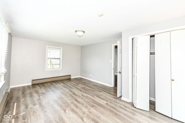 1543 W 79th St, Indianapolis, IN 46260 - unfurnished bedroom featuring a baseboard radiator, light wood-style flooring, and a closet