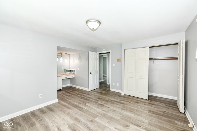 1543 W 79th St, Indianapolis, IN 46260 - unfurnished bedroom with light wood-style flooring, a closet, and built in desk