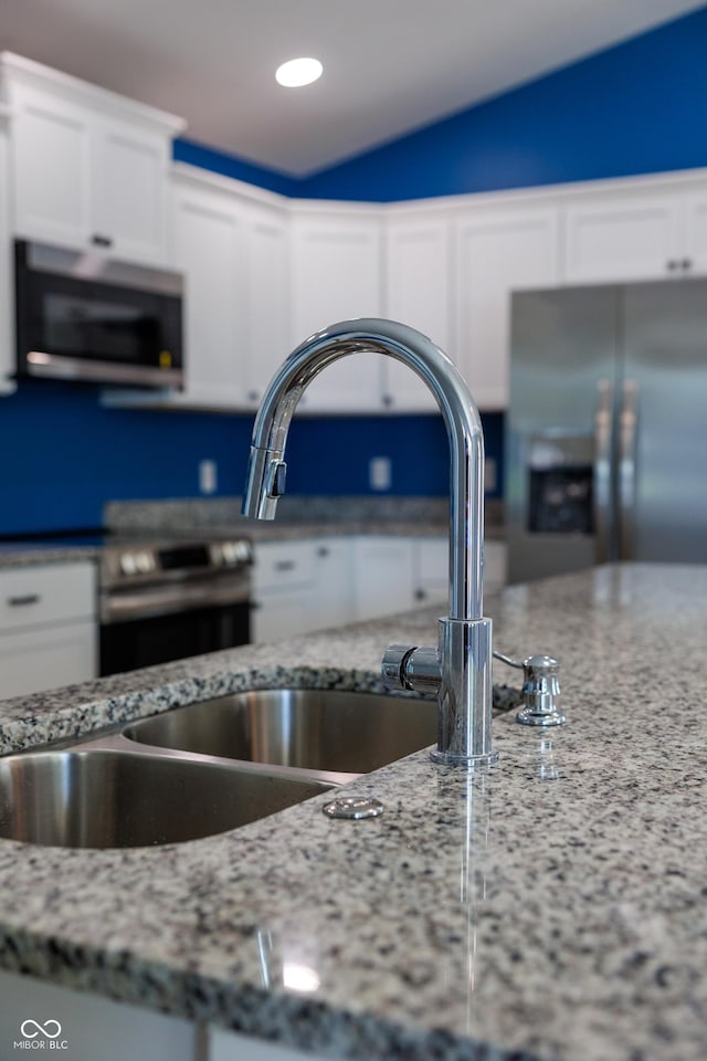 5122 W Legrande Ave, Indianapolis, IN 46241 - kitchen view of appliances with stainless steel finishes, white cabinetry, light stone countertops, and recessed lighting