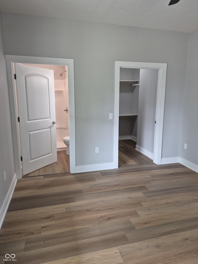 1501 California St, Columbus, IN 47201 - unfurnished bedroom featuring wood finished floors, ensuite bath, a walk in closet, and a closet
