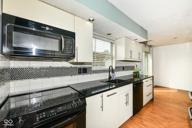 1124 Paradise Ct Unit B, Greenwood, IN 46143 - kitchen with black appliances, white cabinets, decorative backsplash, dark countertops, and light wood-style flooring