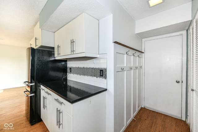 1124 Paradise Ct Unit B, Greenwood, IN 46143 - kitchen with freestanding refrigerator, dark countertops, wood finished floors, tasteful backsplash, and white cabinetry