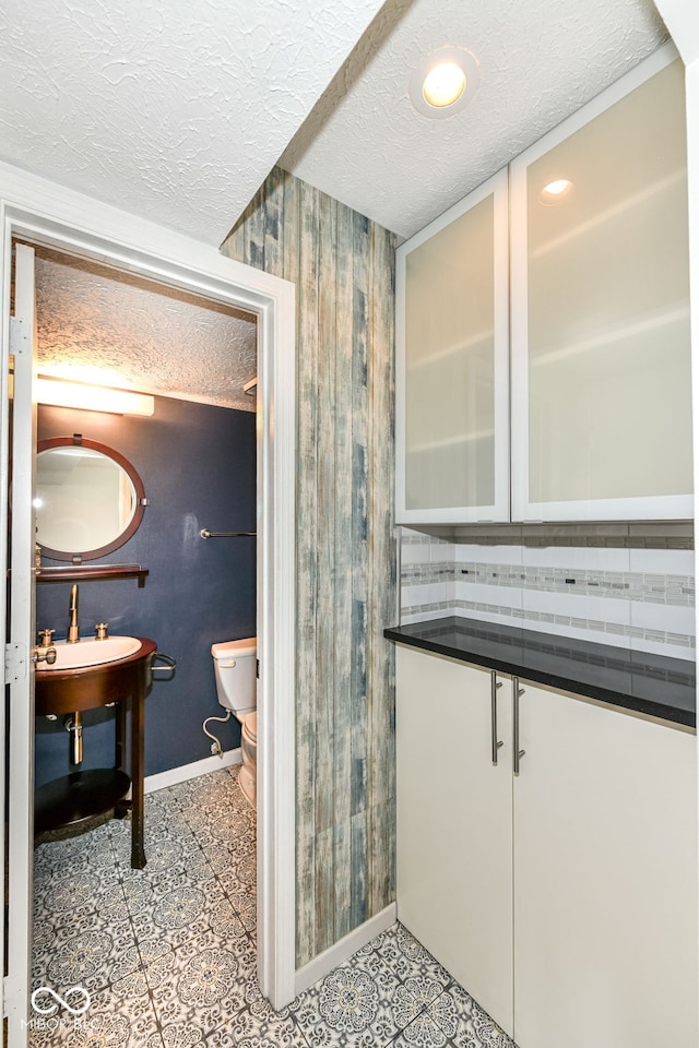 1124 Paradise Ct Unit B, Greenwood, IN 46143 - half bathroom featuring a textured ceiling, wood walls, and decorative backsplash