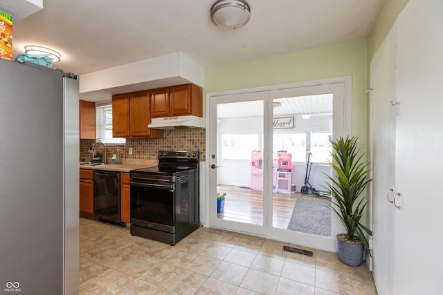2170 N Old State Road 9, Columbus, IN 47203 - kitchen featuring black appliances, under cabinet range hood, brown cabinets, light countertops, and tasteful backsplash