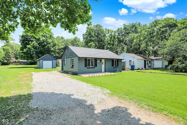 6949 Crittenden Ave, Indianapolis, IN 46220 - view of front of house with gravel driveway, an outbuilding, a detached garage, a front lawn, and a shingled roof