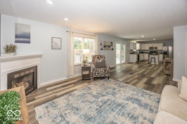 12845 Touchdown Dr, Fishers, IN 46037 - living room featuring dark wood finished floors, a fireplace, and recessed lighting