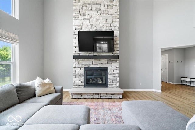 4253 Ironclad Dr, Bargersville, IN 46106 - living area featuring a towering ceiling, wood finished floors, healthy amount of natural light, and a fireplace