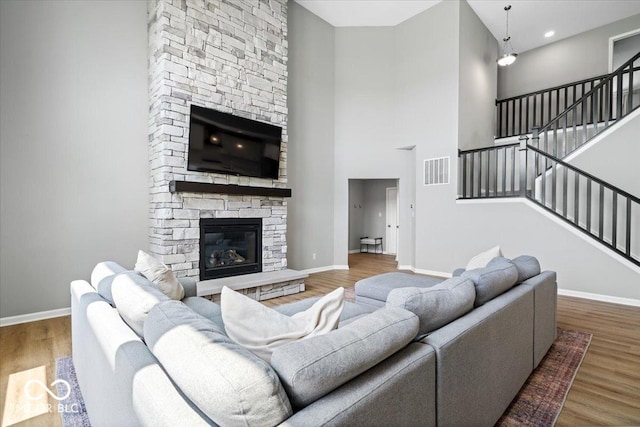 4253 Ironclad Dr, Bargersville, IN 46106 - living area featuring a fireplace, wood finished floors, stairway, and a high ceiling