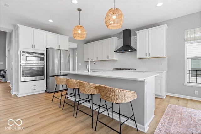 4253 Ironclad Dr, Bargersville, IN 46106 - kitchen with wall chimney range hood, appliances with stainless steel finishes, decorative backsplash, a breakfast bar area, and recessed lighting