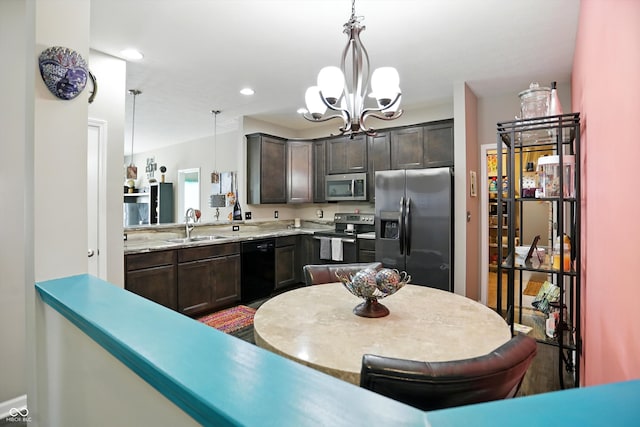 6315 Emerald Field Way, Indianapolis, IN 46221 - kitchen featuring appliances with stainless steel finishes, a chandelier, dark brown cabinets, light countertops, and pendant lighting