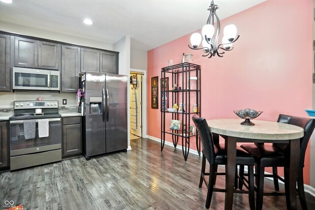 6315 Emerald Field Way, Indianapolis, IN 46221 - kitchen with appliances with stainless steel finishes, wood finished floors, a chandelier, light countertops, and hanging light fixtures