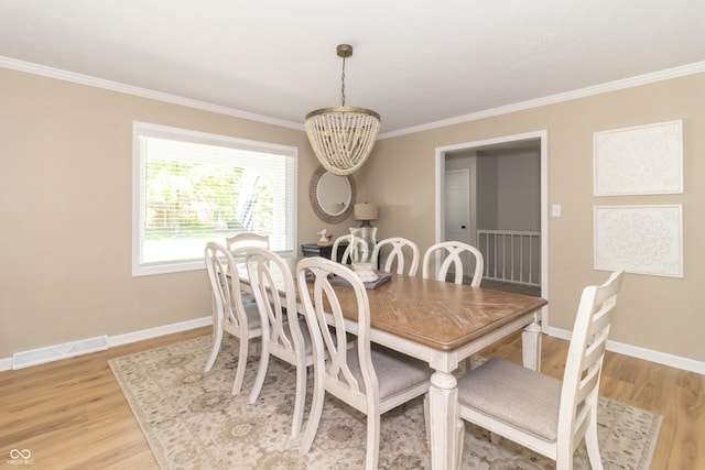 8429 Catamaran Dr, Indianapolis, IN 46236 - dining space with light wood finished floors, ornamental molding, and a chandelier