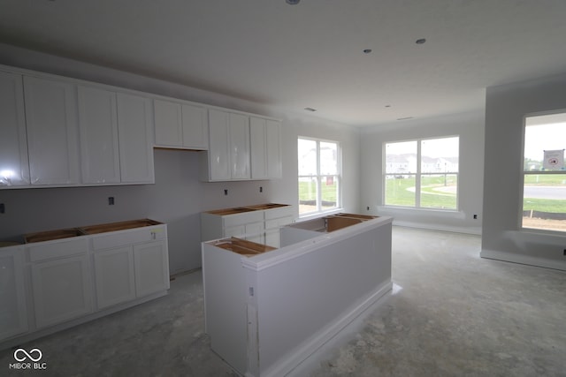 12524 Morning Ridge Way, Noblesville, IN 46060 - kitchen featuring unfinished concrete floors, a center island, and white cabinets