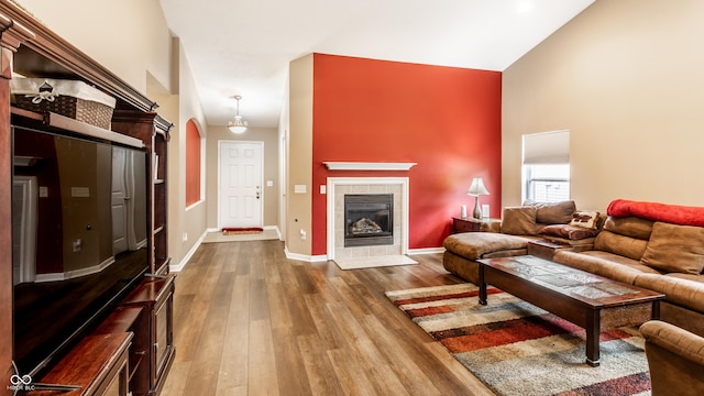 8116 Harshaw Dr, Indianapolis, IN 46239 - living area with wood finished floors, a towering ceiling, arched walkways, and a fireplace