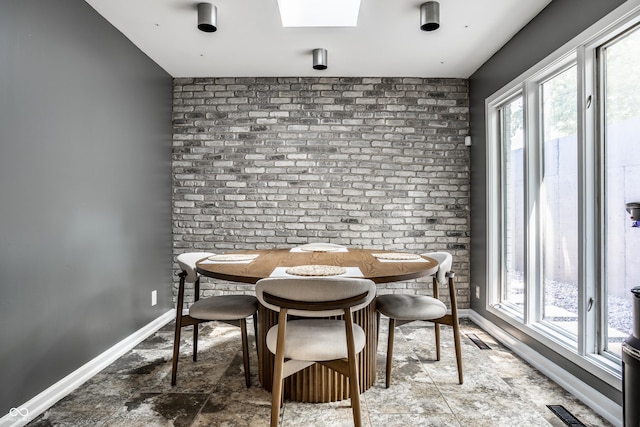 6164 Afton Crst, Indianapolis, IN 46220 - dining area with stone finish flooring, a skylight, and brick wall