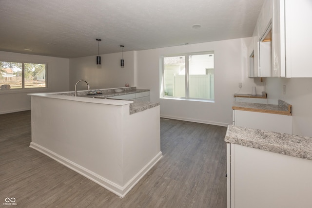 12003 Broadway St, Indianapolis, IN 46236 - kitchen featuring dark wood-type flooring, white cabinets, light countertops, a textured ceiling, and a center island with sink