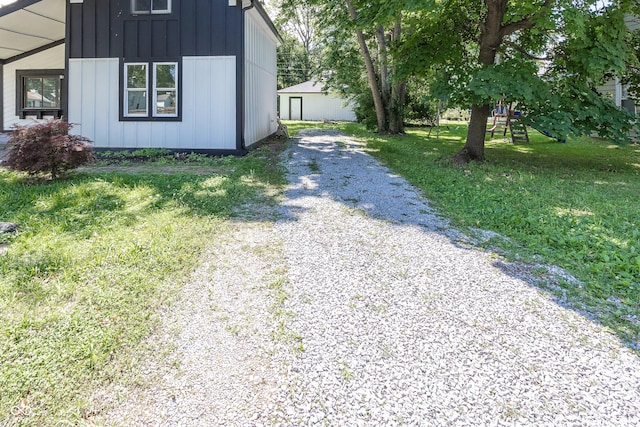 12003 Broadway St, Indianapolis, IN 46236 - view of home's exterior featuring driveway, board and batten siding, and a playground