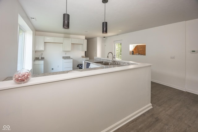 12003 Broadway St, Indianapolis, IN 46236 - kitchen with dark wood-style floors, white cabinets, light countertops, and hanging light fixtures