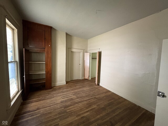 807 N Elm St, Muncie, IN 47305 - unfurnished bedroom with dark wood finished floors and multiple windows