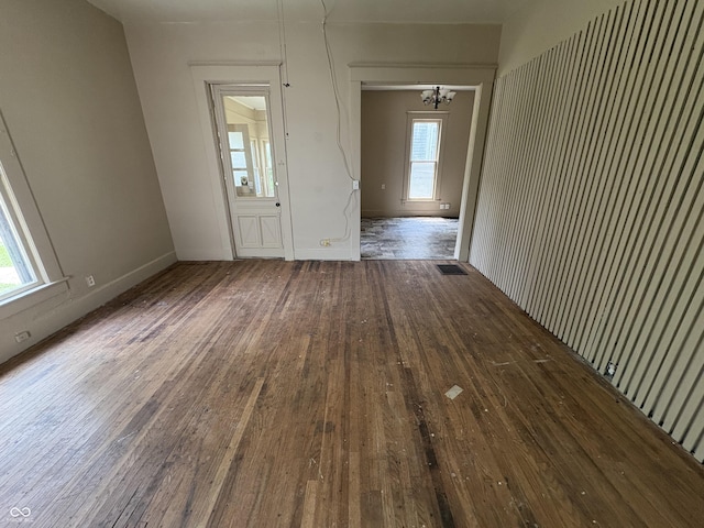 807 N Elm St, Muncie, IN 47305 - empty room with hardwood / wood-style floors, healthy amount of natural light, and a chandelier