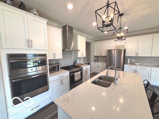 520 Ferndale Ln, Danville, IN 46122 - kitchen with appliances with stainless steel finishes, wall chimney exhaust hood, a kitchen island with sink, crown molding, and tasteful backsplash