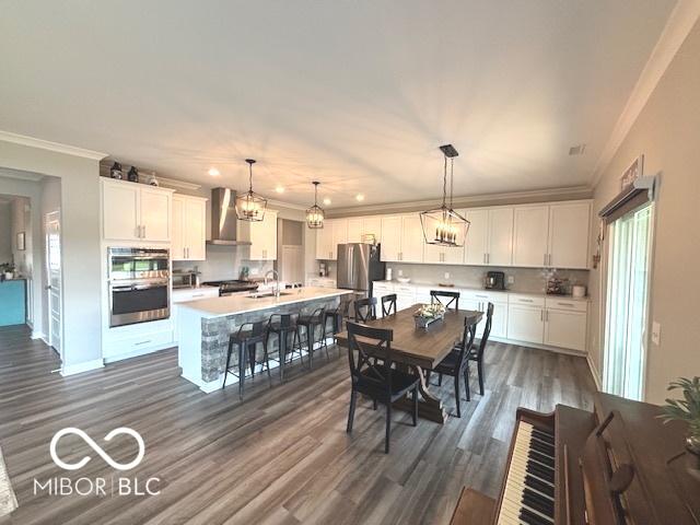 520 Ferndale Ln, Danville, IN 46122 - dining room with crown molding, dark wood-style flooring, recessed lighting, and a chandelier