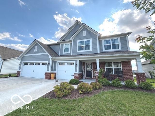 520 Ferndale Ln, Danville, IN 46122 - craftsman inspired home featuring concrete driveway, brick siding, covered porch, a front lawn, and an attached garage