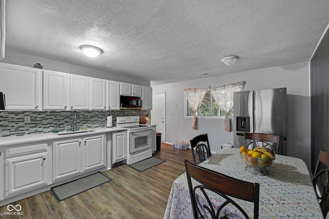 3509 N Wittfield St, Indianapolis, IN 46235 - kitchen with electric range, stainless steel refrigerator with ice dispenser, black microwave, light countertops, and white cabinetry