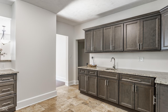 525 Orange St, Indianapolis, IN 46203 - kitchen with dark brown cabinets, stone tile floors, and light stone counters