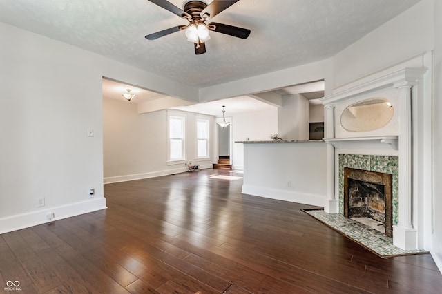 525 Orange St, Indianapolis, IN 46203 - unfurnished living room featuring ceiling fan, a tiled fireplace, and dark wood-style flooring