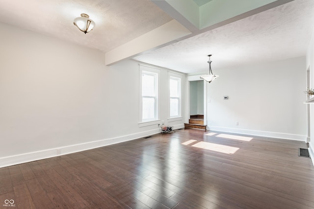 525 Orange St, Indianapolis, IN 46203 - unfurnished living room featuring beamed ceiling, wood finished floors, and a textured ceiling