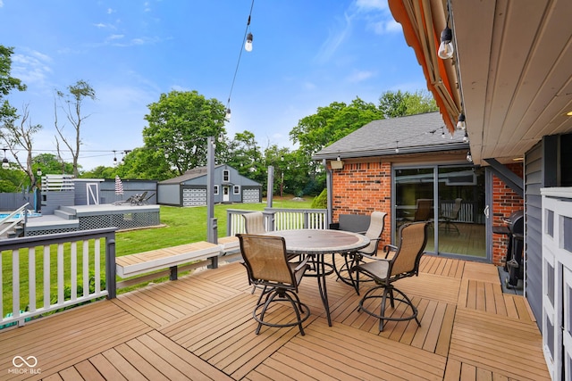 12196 N Beth Ann Dr, Camby, IN 46113 - wooden deck featuring outdoor dining area, a yard, and an outdoor structure