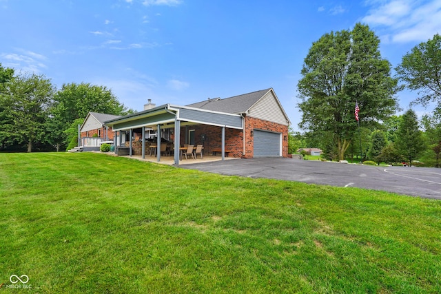 12196 N Beth Ann Dr, Camby, IN 46113 - view of home's exterior with brick siding, an attached garage, a chimney, a lawn, and driveway