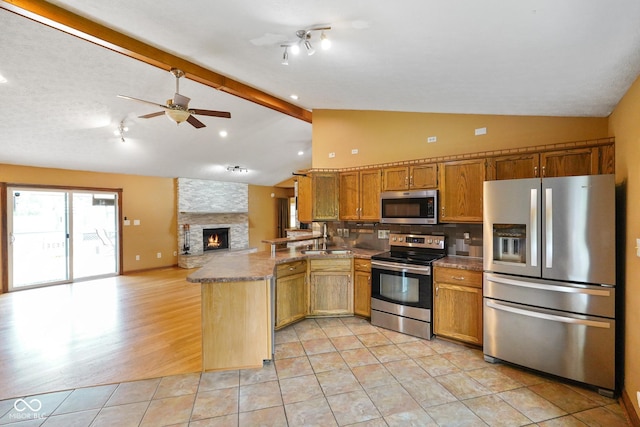 12196 N Beth Ann Dr, Camby, IN 46113 - kitchen featuring appliances with stainless steel finishes, a peninsula, open floor plan, ceiling fan, and brown cabinets