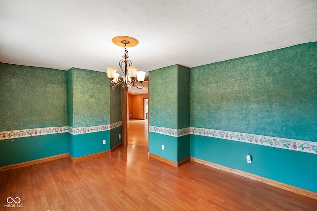 12196 N Beth Ann Dr, Camby, IN 46113 - spare room with wood finished floors, a chandelier, and wallpapered walls