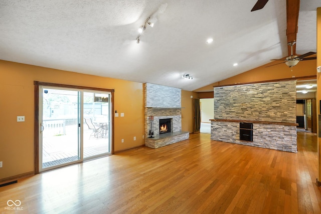12196 N Beth Ann Dr, Camby, IN 46113 - unfurnished living room featuring a stone fireplace, ceiling fan, light wood-style floors, and vaulted ceiling