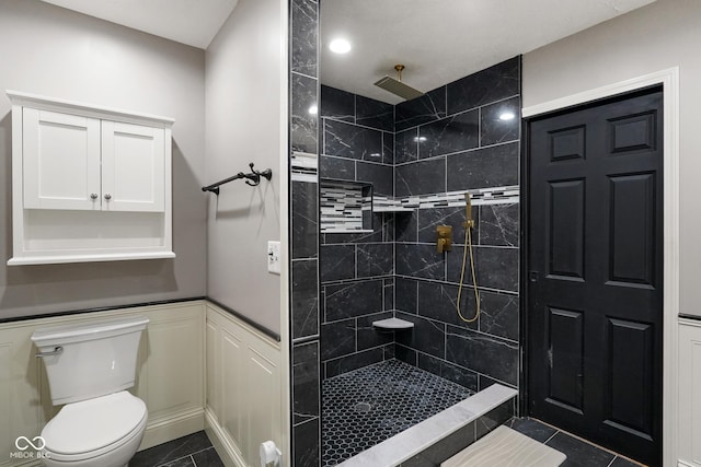 12196 N Beth Ann Dr, Camby, IN 46113 - bathroom with a tile shower, wainscoting, and tile patterned flooring