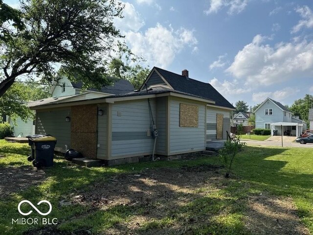 827 W 9th St, Anderson, IN 46016 - view of side of home with a yard and a chimney