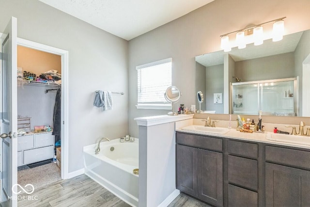 1758 Pelham Dr, Greenwood, IN 46143 - full bath featuring a stall shower, wood finished floors, a walk in closet, a garden tub, and double vanity