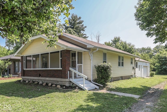 2245 N Ritter Ave, Indianapolis, IN 46218 - view of front of home featuring a front yard, a garage, brick siding, and a sunroom