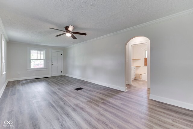 2245 N Ritter Ave, Indianapolis, IN 46218 - empty room featuring crown molding, a textured ceiling, a ceiling fan, wood finished floors, and arched walkways