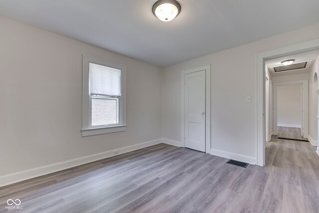 2245 N Ritter Ave, Indianapolis, IN 46218 - unfurnished bedroom featuring light wood finished floors, attic access, and a closet