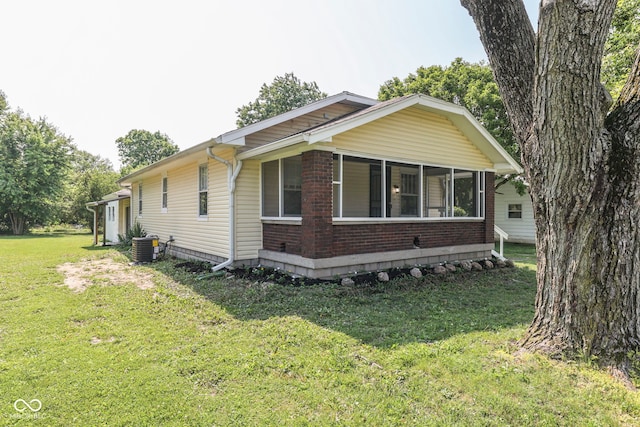 2245 N Ritter Ave, Indianapolis, IN 46218 - view of property exterior with a yard, brick siding, and a sunroom