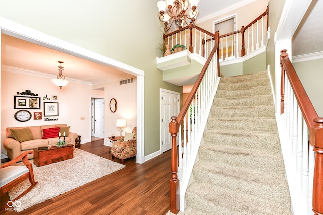 9825 Covington Blvd, Fishers, IN 46037 - staircase featuring crown molding, wood finished floors, a chandelier, and a high ceiling