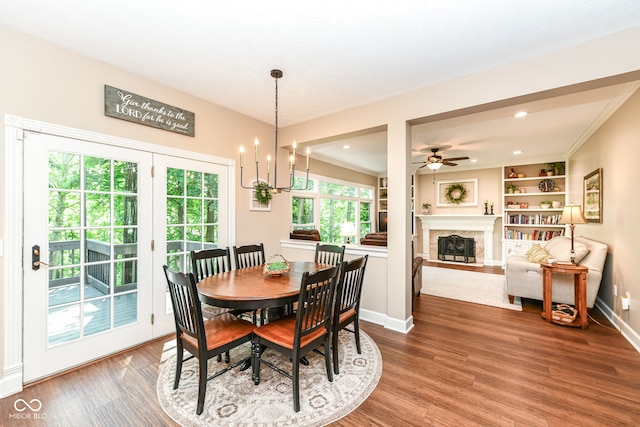 9825 Covington Blvd, Fishers, IN 46037 - dining room with wood finished floors, ceiling fan, a fireplace, and a chandelier