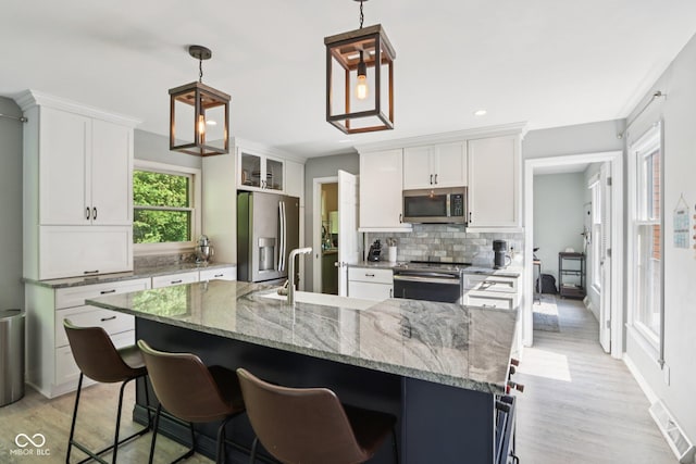 7029 Kingswood Cir, Indianapolis, IN 46256 - kitchen with appliances with stainless steel finishes, backsplash, light wood finished floors, white cabinetry, and recessed lighting